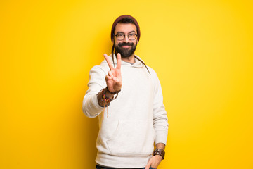 Hippie man with dreadlocks smiling and showing victory sign