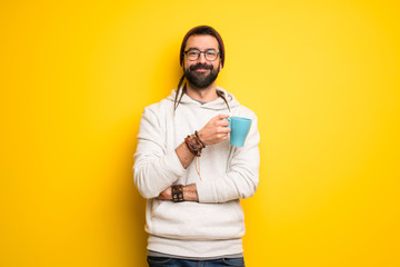 Hippie man with dreadlocks holding a hot cup of coffee - Powered by Adobe