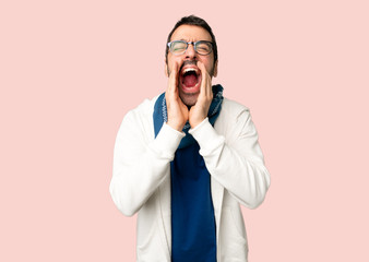 Handsome man with glasses shouting and announcing something on isolated pink background