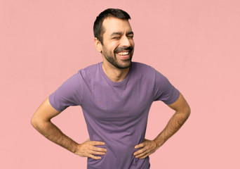 Handsome man happy and smiling on isolated pink background