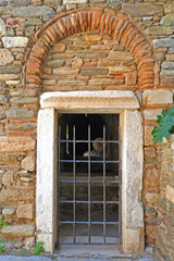 Fototapeta na wymiar entrance to the abandoned secondary chapel of Kaisariani byzantine medieval monastery, Athens Greece