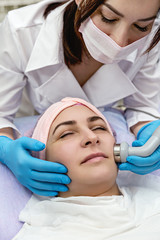 Rejuvenating facial treatment. Model getting lifting therapy massage in beauty SPA salon. Exfoliation, rejuvenation and hydration. Model and Doctor. Cosmetology. Close up.