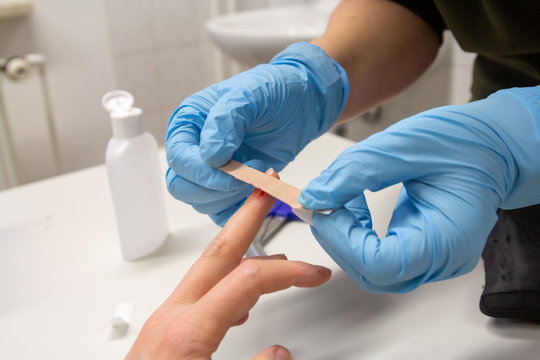 a doctor sticks a plaster on a finger