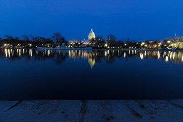 Spectacular night-time urban vista looking eastwards across the Capitol Reflecting Pool towards the illuminated United States Capitol building