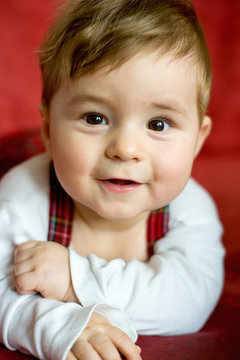 portrait eines glücklichen kleinen Jungen vor rotem Hintergrund