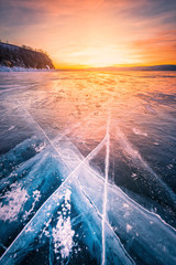 Sunset sky with natural breaking ice over frozen water on Lake Baikal, Siberia, Russia.