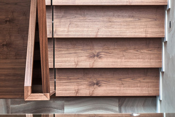 Part of wooden steps with glass railings. Walnut staircase
