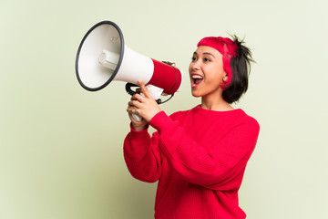 Young woman with red sweater shouting through a megaphone