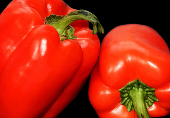 Macro. Bell pepper on black background. Two red peppers. Isolated backdrop. Closeup.  Vegetables. Organic food.