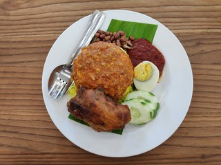 Nasi lemak serve with fried chicken,egg,anchovies,cucumber sliced,sambal and ground nuts.
