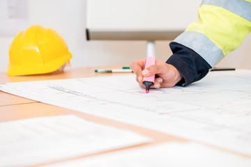 Contractor Using Pink Highlighter On Blueprint