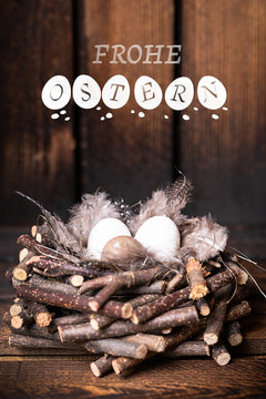 Nest mit Eiern und Ostergruß vor Holzhintergrund