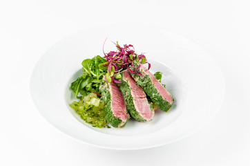 Tuna in herbs with ginger melon on a plate on a white background