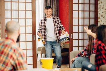 Happy friends going to drink a beer at home party