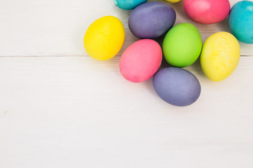 Fototapeta na wymiar Pastel Easter eggs on rustic whote wooden table