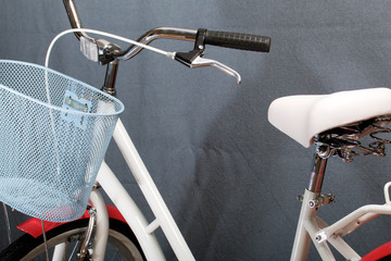Elements of a female bicycle in white and pink color.  Steering wheel and luggage basket. Spring and summer recreation and sports.