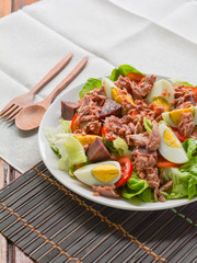 tuna salad with boiled egg, tomato slice, sweet potato and lettuce on white dish. Healthy food for loose weight, high fiber and low fat.