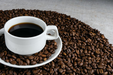Coffee cup and beans on old kitchen table.
