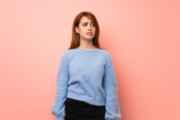 Obraz premium Young redhead woman over pink background is a little bit nervous and scared pressing the teeth