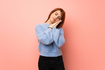 Young redhead woman over pink background making sleep gesture in dorable expression