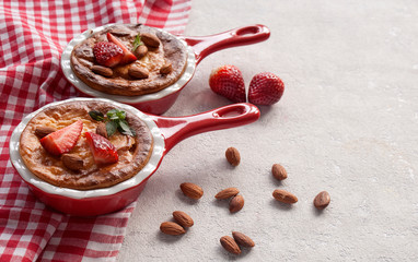 Homemade cottage cheese pudding or casserole with strawberries and almonds in small ceramic pan. Copy space.