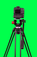 Dslr camera with empty screen on the tripod, isolated on green background. The chromakey. Green screen.