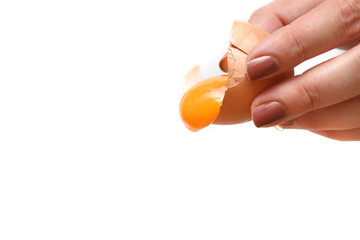 Broken egg, yolk and protein flows down on a white background