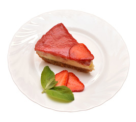 Coseup top view of strawberry cheesecake with mint leaves on white plate on the white background