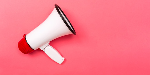 A megaphone on a pink paper background