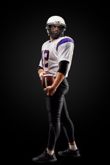 American football sportsman player on black background. Sport concept.