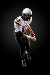 American football sportsman player on black background. Sport concept.