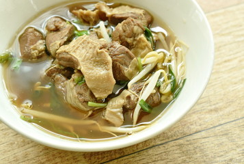 braised pork and bean sprout in brown soup on bowl