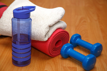 dumbbells mat and a bottle of water