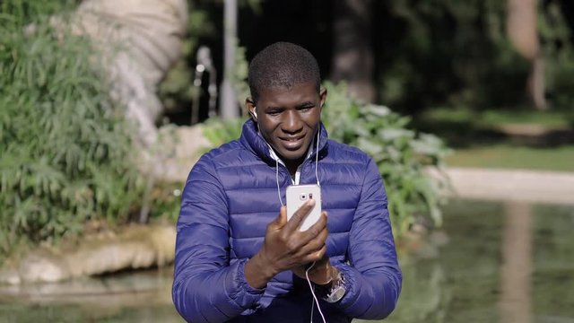 African black man making videocall wit smartphone in the park