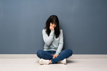 Woman sitting on the floor having doubts