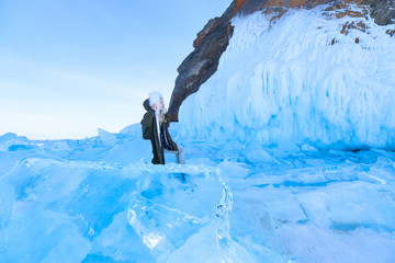 Woman on Lake Baikal among ice and snow rocks