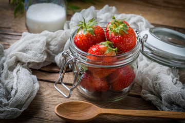 Strawberry in jar on wooden background.