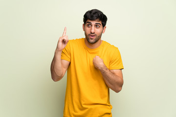 Young man over pink wall with surprise and shocked facial expression