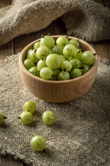 Fresh gooseberry in a wooden bowl.