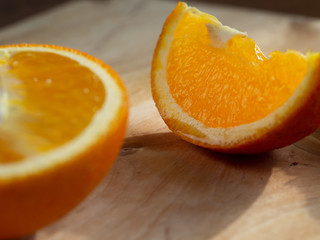 Two juicy orange slices on the table, illuminated by the light from the window.