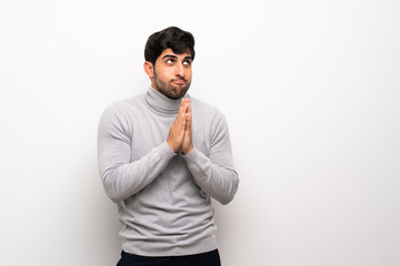 Young man over isolated white wall scheming something