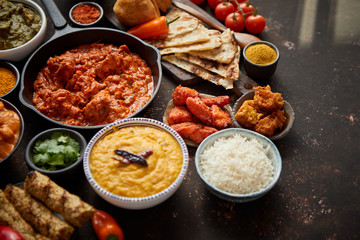 Assortment of various kinds of Indian cousine on dark rusty table