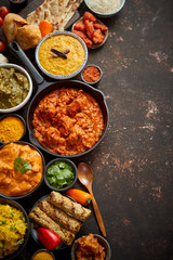Assortment of various kinds of Indian cousine on dark rusty table