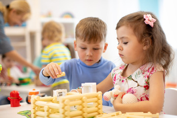 Kindergarten kids playing toy in playroom at preschool, education concept.