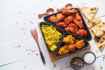 Spicy indian fried chicken served with curry vegetable rice, onion bhajia, naan bread