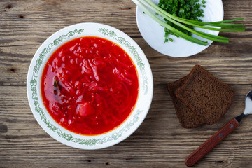 Traditional  ukrainian vegetarian beet red soup - borscht on wooden background. Top view.