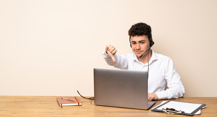 Telemarketer man showing thumb down with negative expression