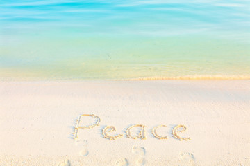 The Word Peace Written in the Sand on a Beach with morning sea background