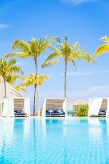 Luxury White beach bed chairs, cabanas, lounge Sundeck by swimming pool side, vertical composition
