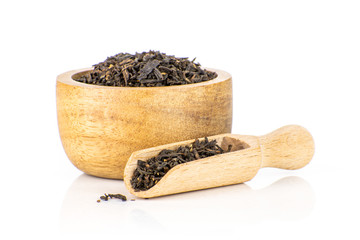 Lot of pieces of dry black tea earl grey with wooden bowl and wooden scoop isolated on white background